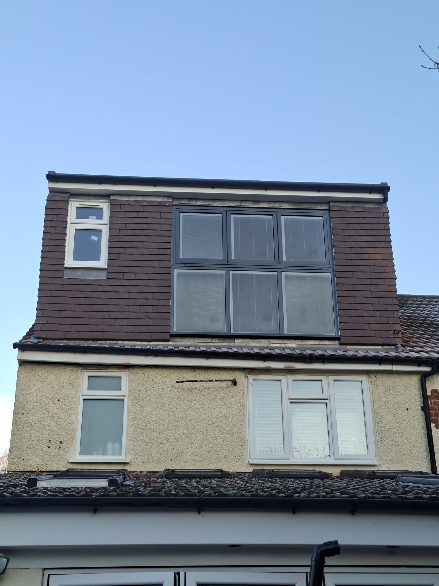 Dormer loft conversion exterior front view with new tiles and windows