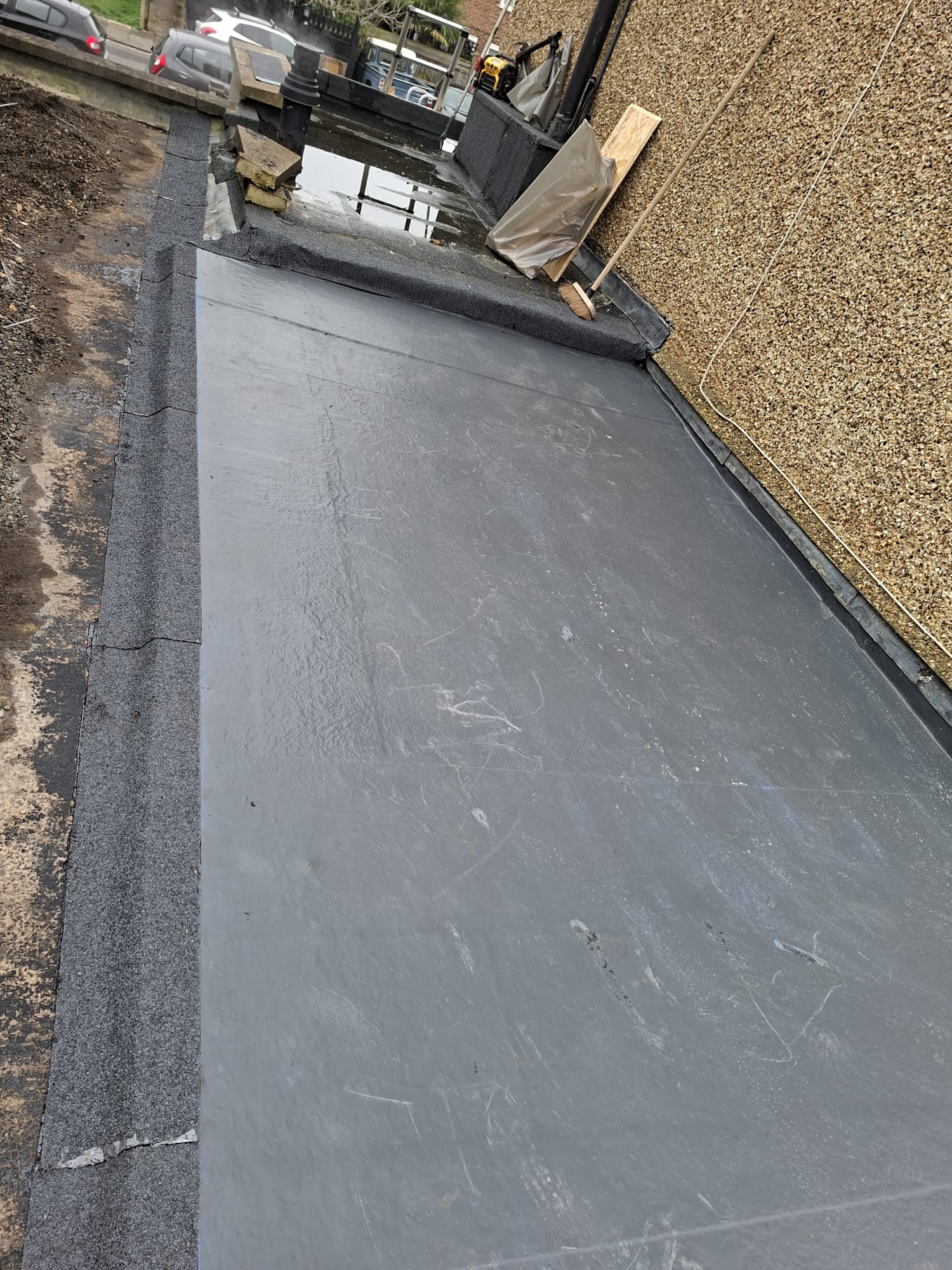 EPDM rubber roof membrane being installed on flat roof extension