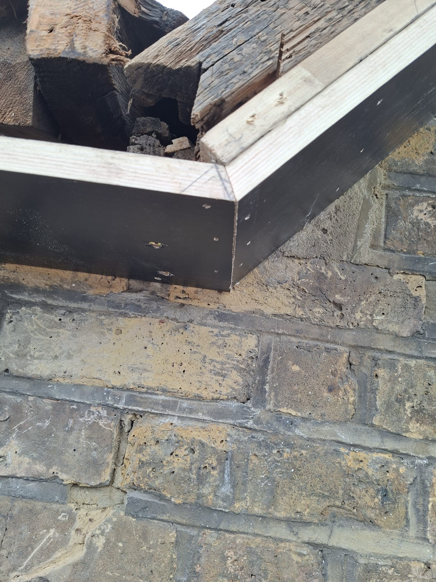 New fascia board fitted with timber frame on brick wall