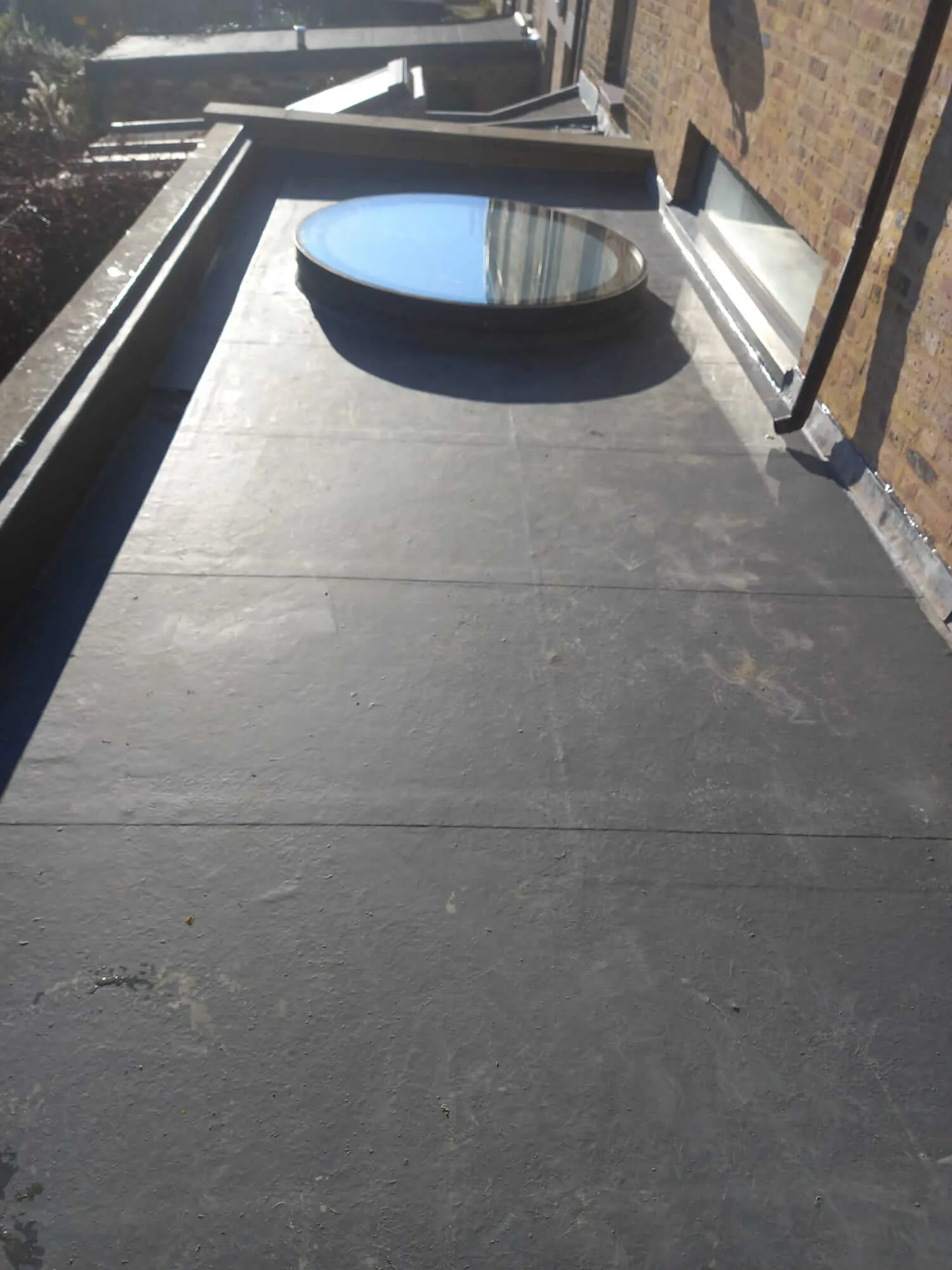 EPDM rubber flat roof with circular skylight installation in North London