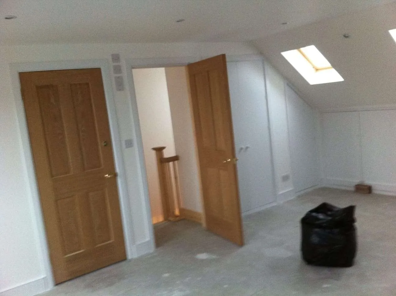 Completed loft conversion with oak doors, Velux skylight and recessed lighting