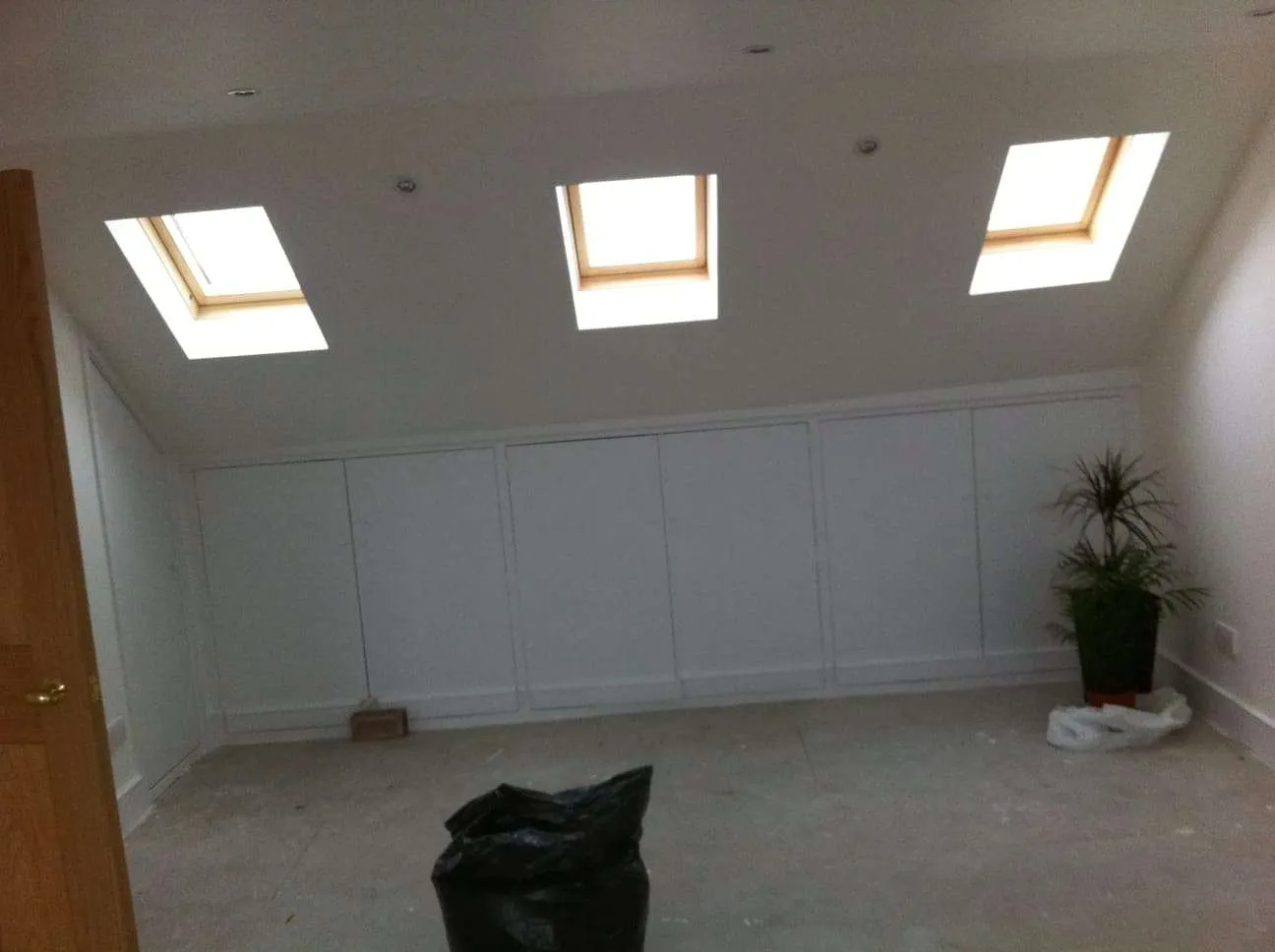 Loft conversion with built-in eaves storage cupboards and three Velux windows