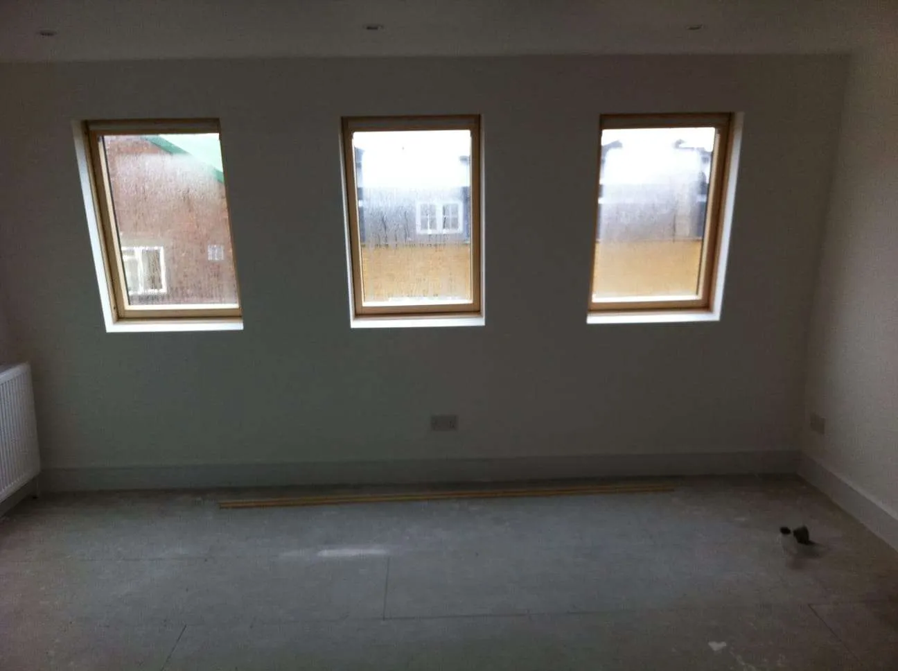 Finished loft conversion room with three Velux roof windows flooding the space with natural light