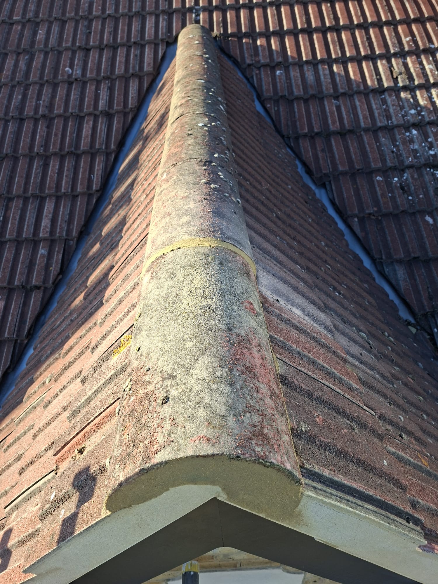 Close-up of roof ridge tiles with mortar on clay tile roof