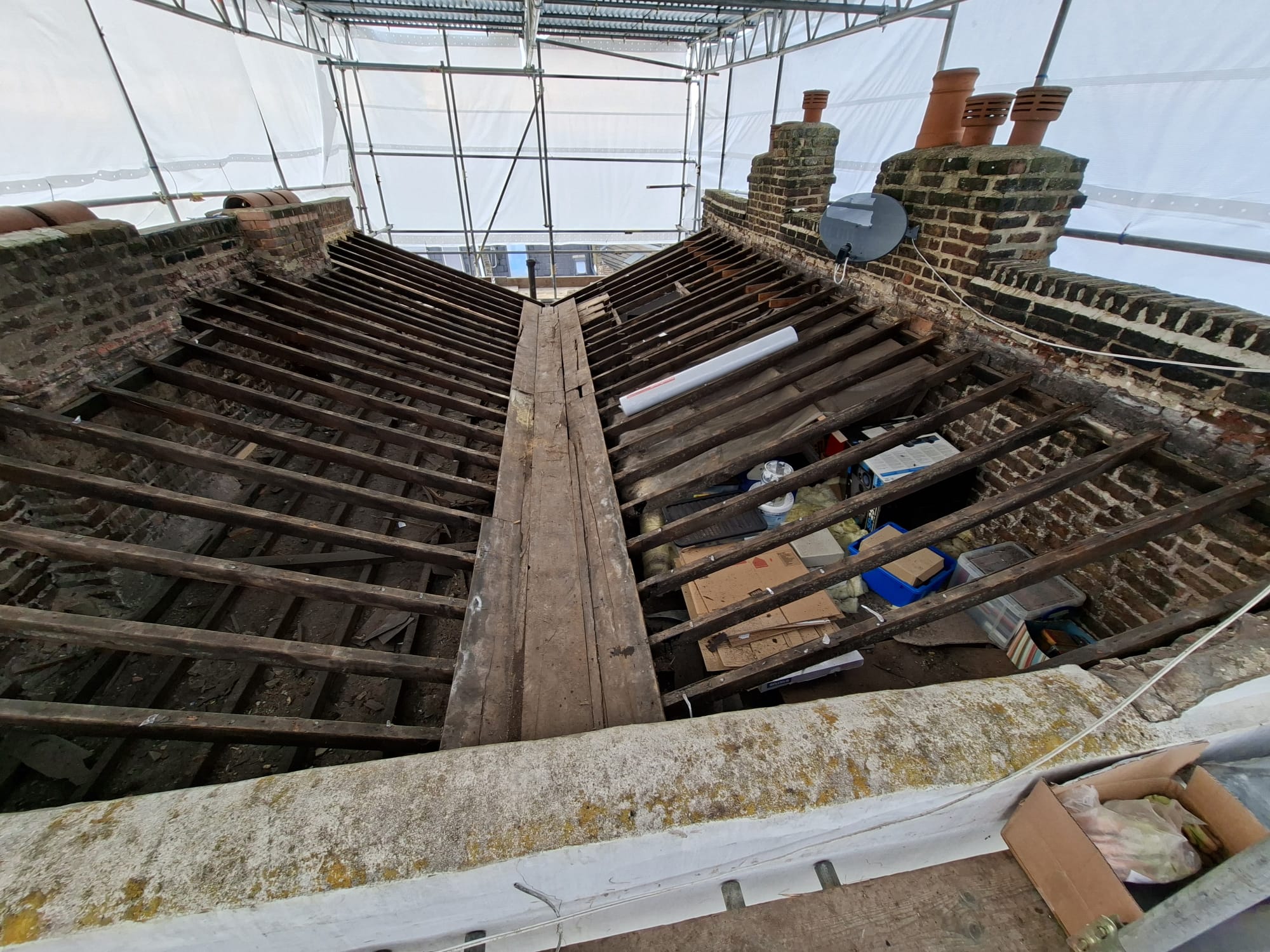 Roof stripped back to rafters under scaffolding during full replacement