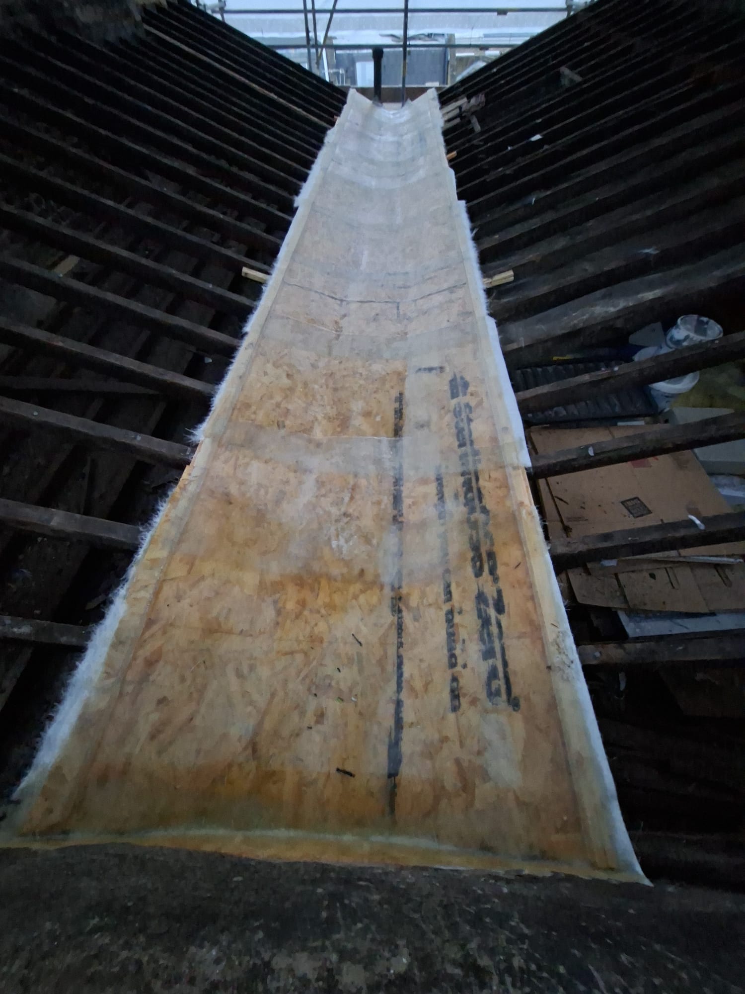 Roof valley lined with OSB board and insulation during replacement