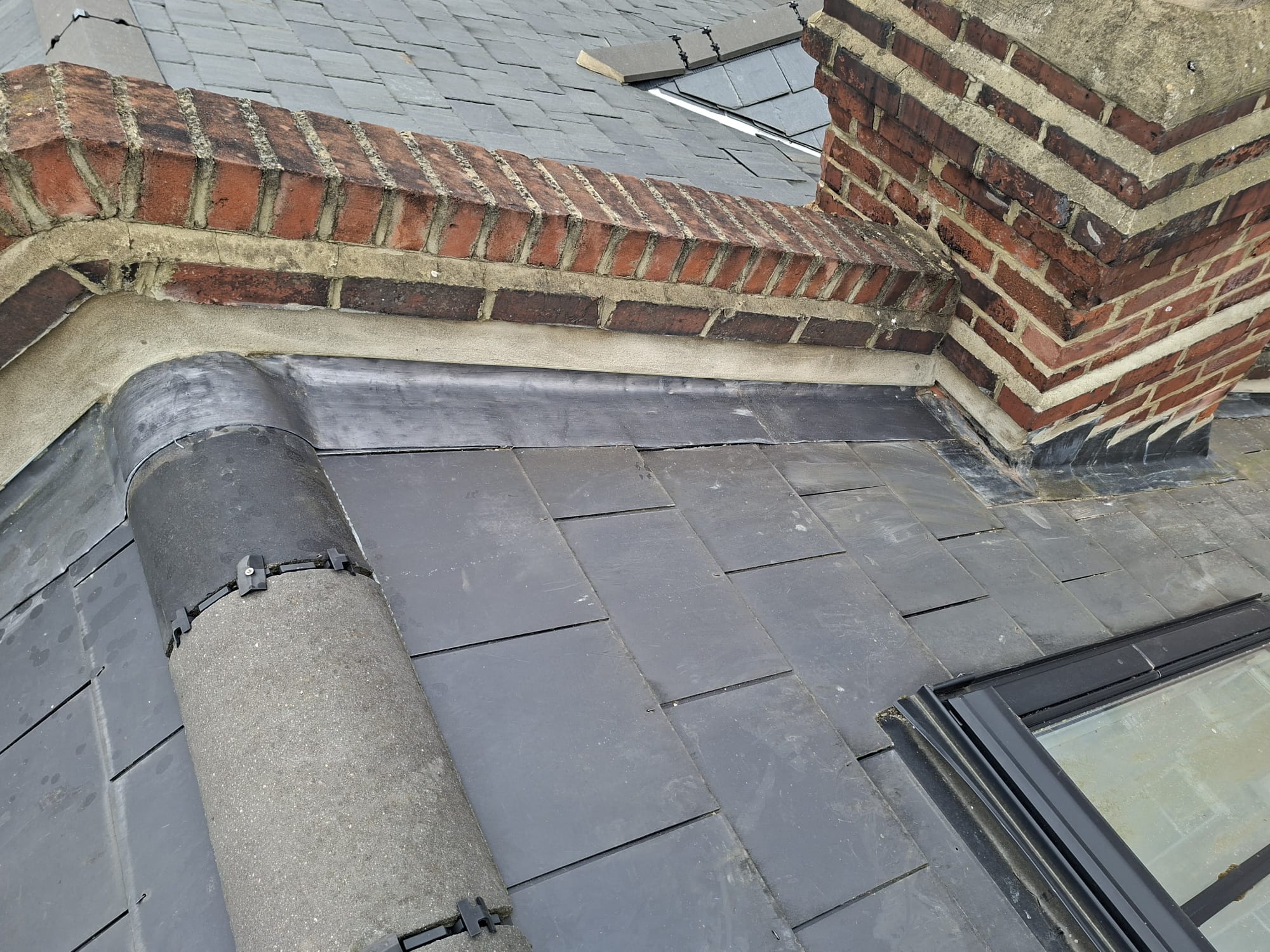 Slate roof with ridge tiles, chimney and Velux window