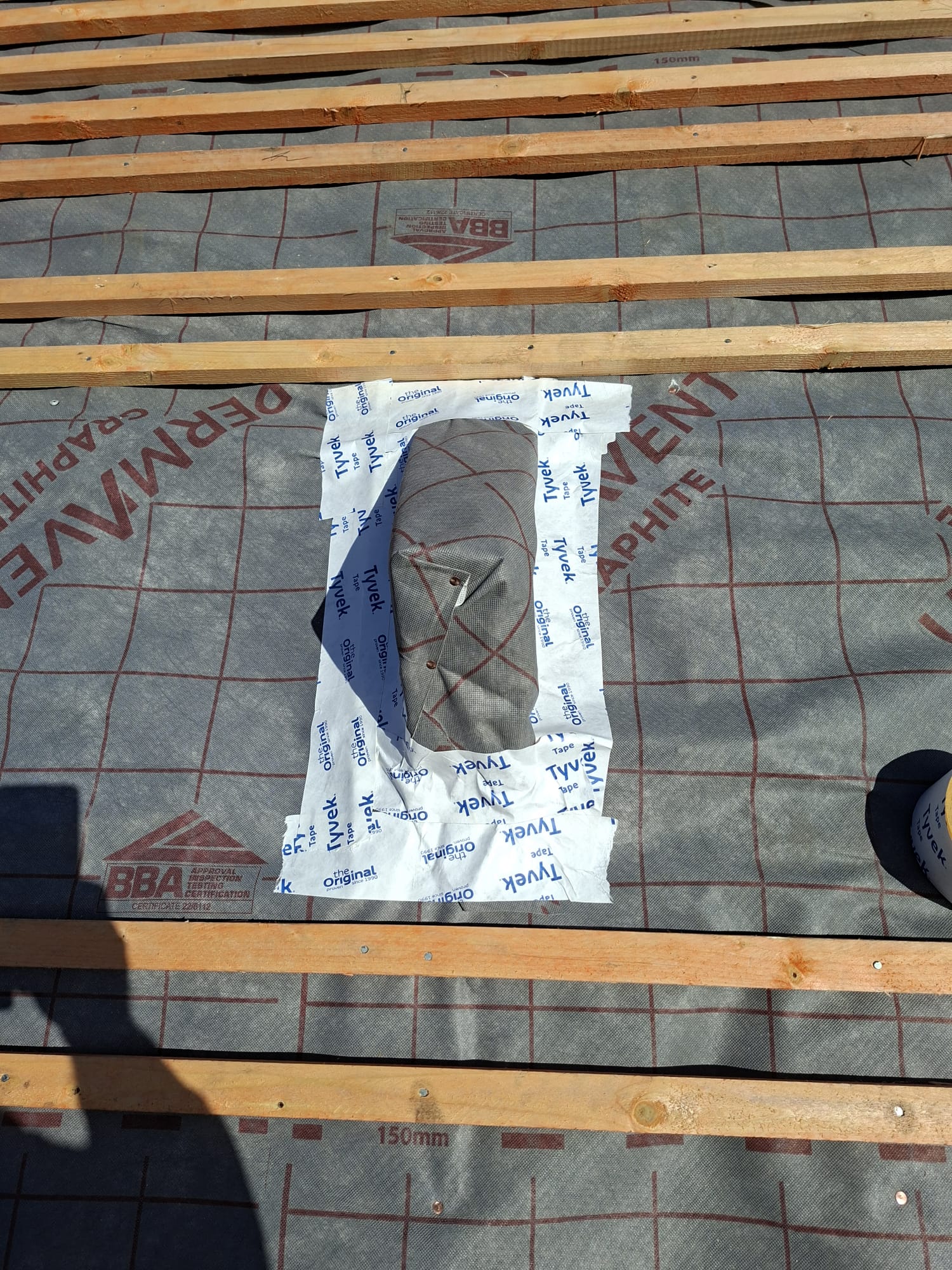 Tyvek tape pipe boot detail on breathable membrane during re-roof