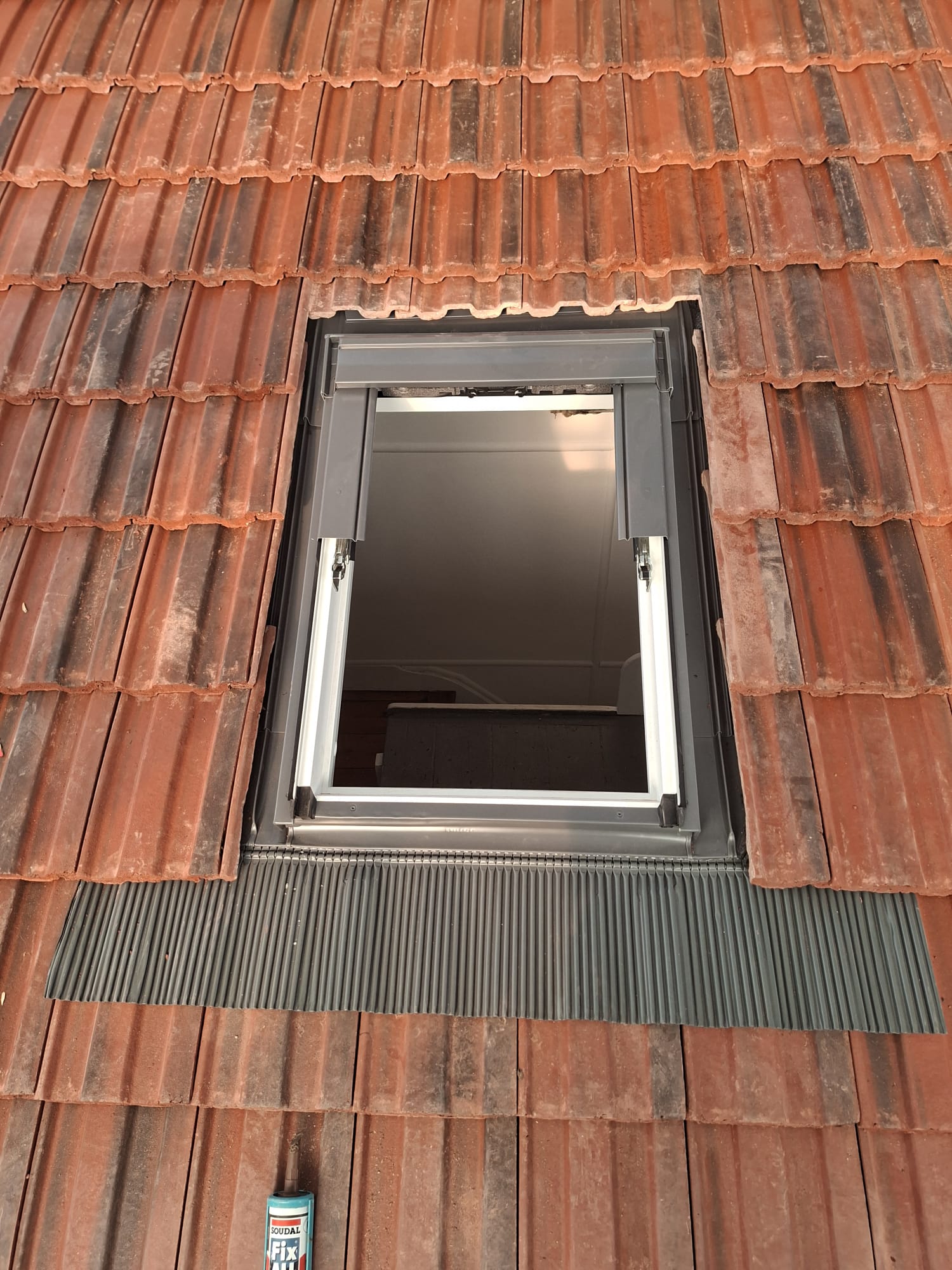 Open Velux skylight in new tiled roof with city views